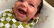 Eden joined the competition — help win amazing prizes! baby, infant, child, smiling, laughing, portrait, close_up, face, eyes, hair, indoors, cushion, blanket, clothing, checkered_pattern, green, white,  버튼, cozy, happy