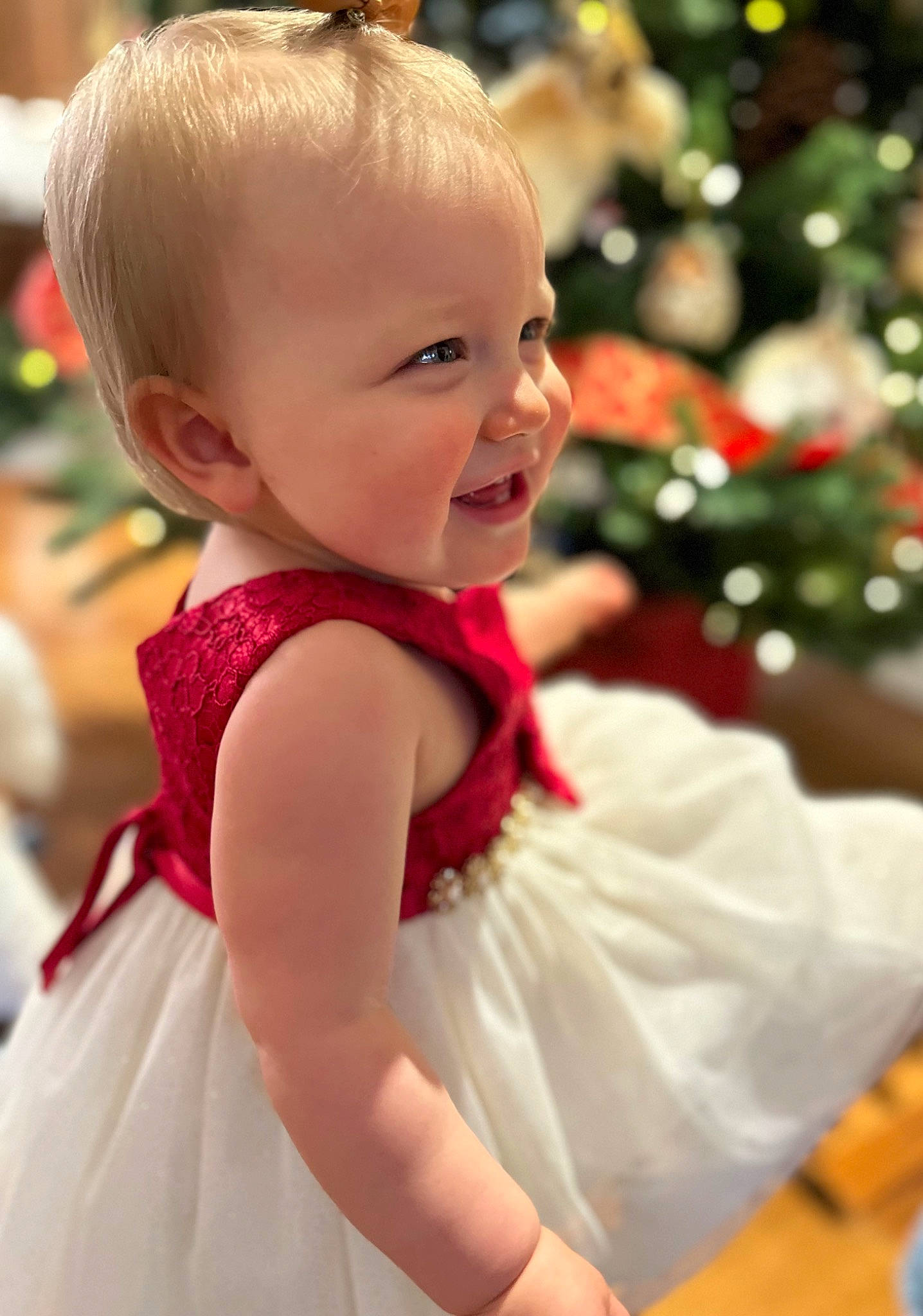 Mae is registered to the contest to win money with this photo: baby, baby_toddler_clothing, blond, child, christmas_tree, dress, event, formal_wear, fun, happy, holiday, iris, magenta, musical_instrument, peach, person, sitting, skin, smile, toddler