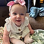 Harper joined the competition — help win amazing prizes! baby, child, pink_bow, headband, white_dress, sitting, smiling, blanket, couch, indoor, soft_lighting, cute, happy, portrait, infant, tights, hand, face, cozy, home