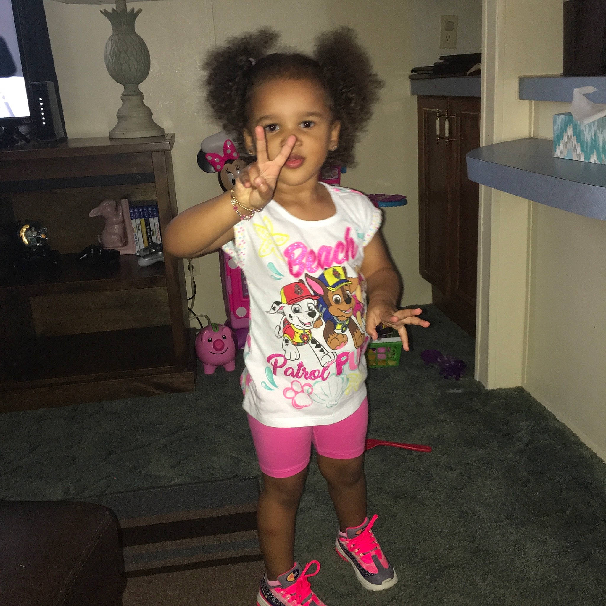 Caylee is registered to the contest to win money with this photo: arm, child, footwear, fun, human_leg, joint, knee, leg, person, pink, play, shoe, shoulder, smile, standing, style, t_shirt, thigh, toddler