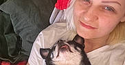 Elvira participe au concours pour gagner de l'argent avec cette photo : woman, dog, pet, smile, selfie, indoor, blanket, couch, relaxing, happy, face, resting, cozy, casual, comfort, light, pillow, white_shirt, small_dog, tongue_out