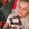 woman, dog, pet, smile, selfie, indoor, blanket, couch, relaxing, happy, face, resting, cozy, casual, comfort, light, pillow, white_shirt, small_dog, tongue_out