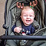 Arlo is registered to the contest to win money with this photo: baby, child, stroller, reindeer_antlers, smiling, holiday, cozy, green, blanket, clothing, person, indoor, shopping, aisle, cute, happy, infant, seat, headwear, festive