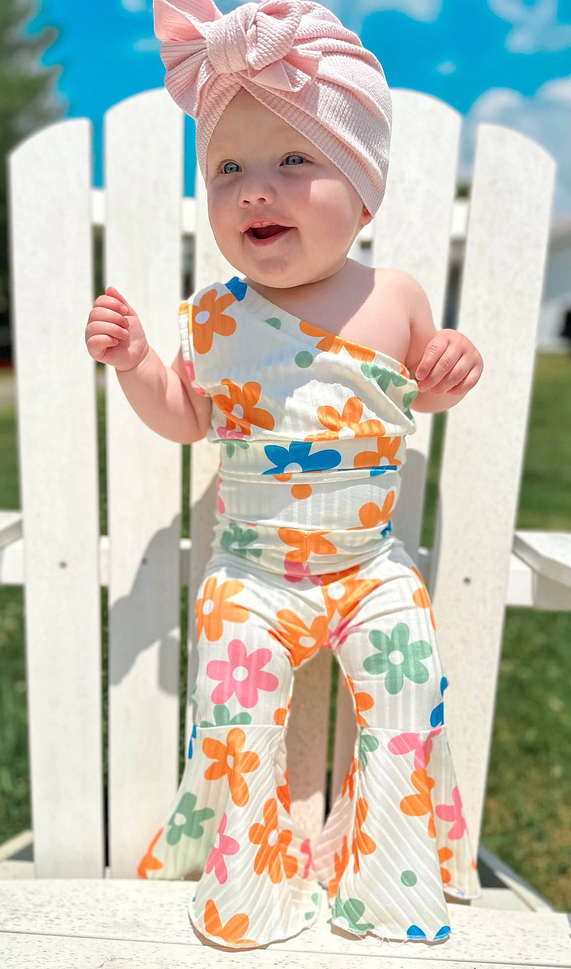 Marleigh is registered to the contest to win money with this photo: baby, bodypart, cap, clothing, dress, face, finger, formalwear, furniture, grass, hand, hat, head, pants, person, photography, plant, portrait, sitting, tape