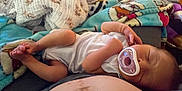 Maverick is registered to the contest to win money with this photo: baby, infant, pacifier, sleeping, blanket, onesie, feet, hands, couch, sofa, naptime, cozy, closeup, domestic, patterned_blanket, torso, newborn, portrait, relaxing, home