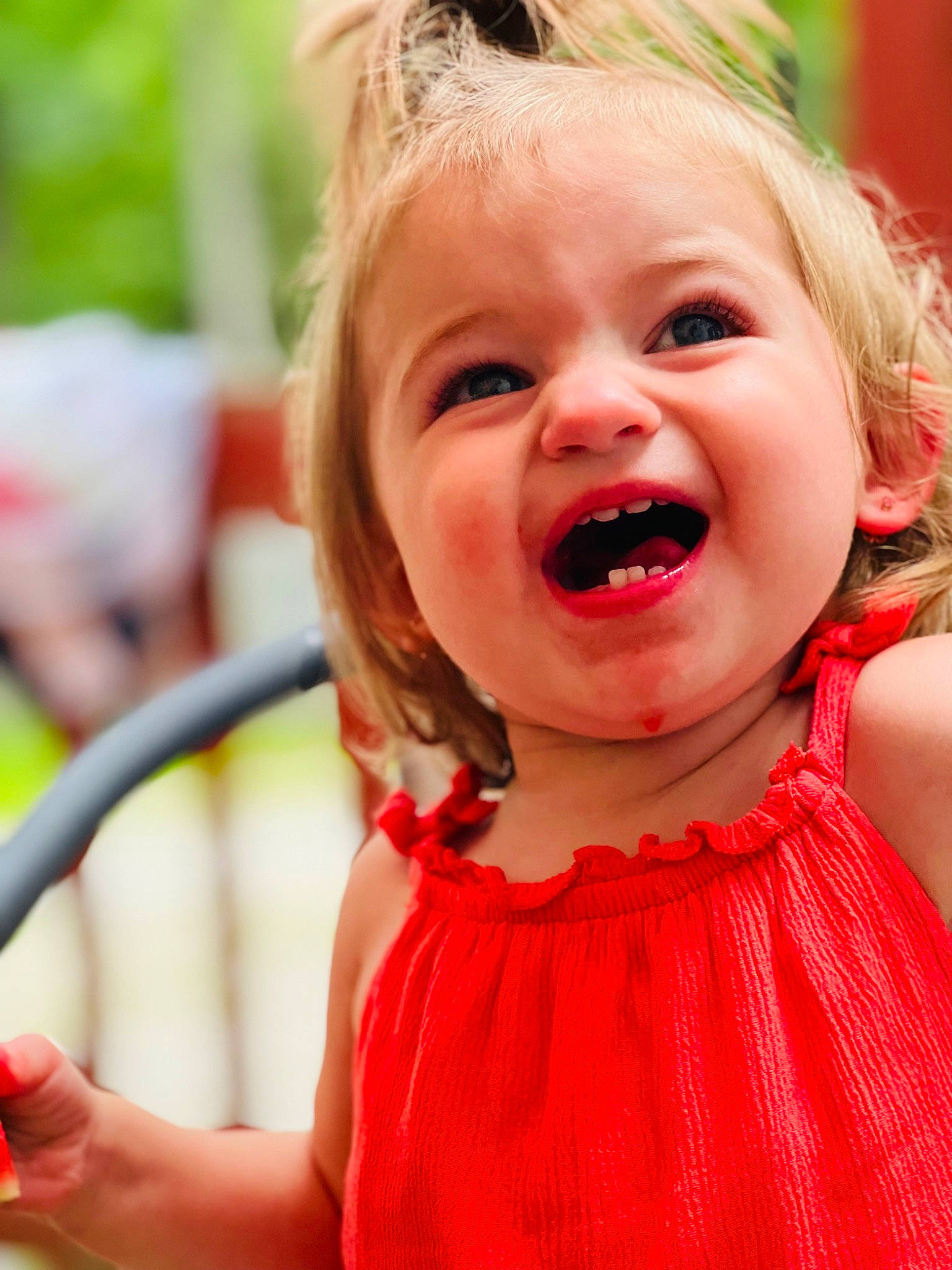 Melanie is registered to the contest to win money with this photo: baby, baby_toddler_clothing, blond, cheek, child, event, eye, facial_expression, fun, grass, happy, lip, nose, people, person, red, skin, sleeve, smile, summer