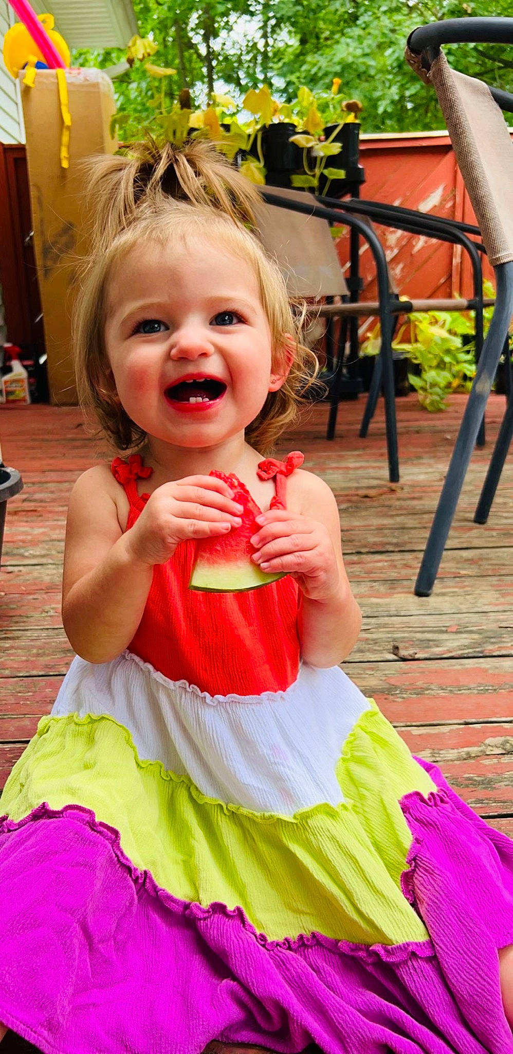 Melanie is registered to the contest to win money with this photo: baby_toddler_clothing, beauty, chair, child, day_dress, dress, fun, green, happy, orange, outdoor_furniture, person, photograph, pink, plant, red, skin, smile, toddler, white