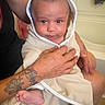 baby, towel, hood, infant, tattoo, arm, hand, bathroom, foot, person, skin, cute, child, wrapped, holding, expression, indoors, human, portrait, newborn