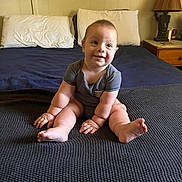 Brayden joined the competition — help win amazing prizes! baby, bed, blanket, blue_sheet, child, cute, face, feet, hands, happy, indoors, infant, lamp, pillows, plump, sitting, skin, smiling, striped_clothing, wooden_nightstand