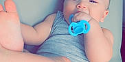Ren is registered to the contest to win money with this photo: baby, infant, pacifier, grey_clothing, barefoot, lying_down, cute, child, skin, head, face, hand, foot, indoors, soft_surface, one_person, playful, relaxed, baby_girl_or_boy, sleepwear