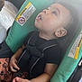 Zy'Aire is registered to the contest to win money with this photo: toddler, child, car_seat, safety_harness, black_shirt, floral_pants, warning_label, seatbelt, indoors, curious, small_hands, face, baby, person, seat, upward_gaze, child_safety, car_interior, young_child, strapped_in