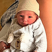 Elio participe au concours pour gagner de l'argent avec cette photo : newborn, baby, infant, hat, onesie, bear_face, hand, legs, blanket, indoor, cozy, cute, soft, person, clothing, skin, portrait, baby_clothes, holding, warm