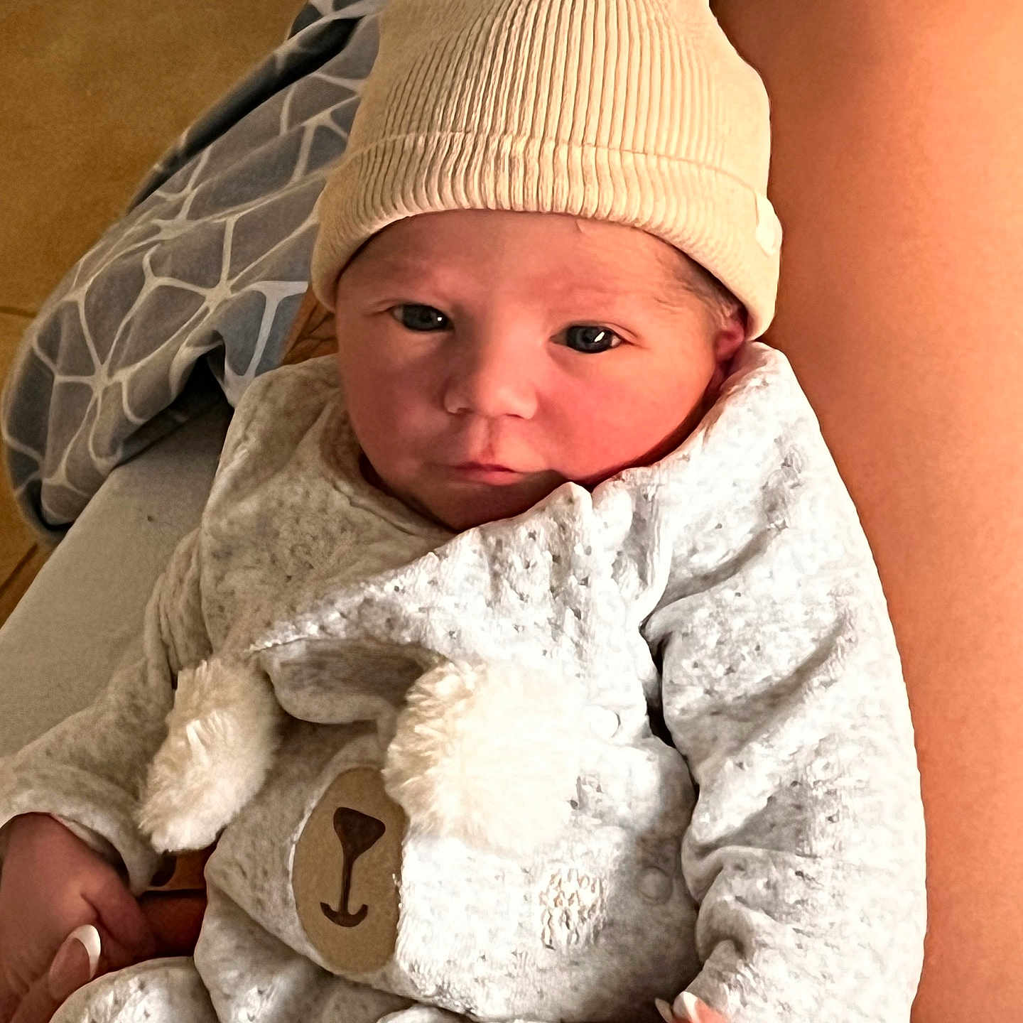 Elio participe au concours pour gagner de l'argent avec cette photo : baby, baby_clothes, bear_face, blanket, clothing, cozy, cute, hand, hat, holding, indoor, infant, legs, newborn, onesie, person, portrait, skin, soft, warm