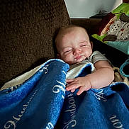 Hudson is registered to the contest to win money with this photo: baby, sleeping, blanket, couch, pillow, indoor, child, infant, comfort, rest, soft, cozy, furniture, relaxation, home, person, peaceful, cute, face, hand
