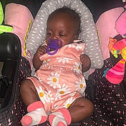 Khalani Cunningham joined the competition — help win amazing prizes! baby, car_seat, child, close_up, colorful, cushion, face, floral_pattern, headrest, indoor, infant, pacifier, photograph, pink_outfit, portrait, relaxed, sitting, sleepy, socks, toy