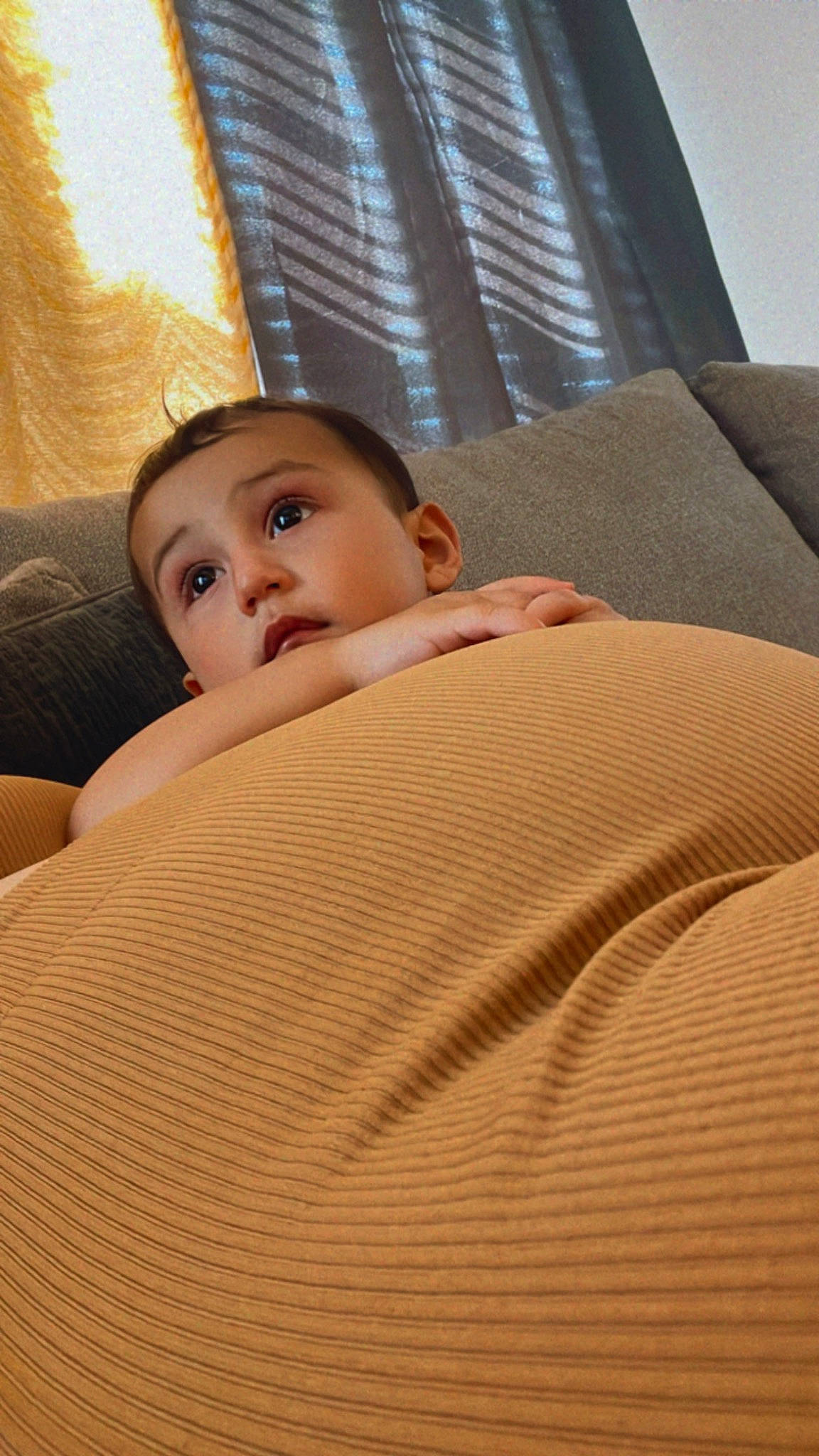 Bryce is registered to the contest to win money with this photo: bed_sheet, bedding, bedroom, car_seat, child, comfort, floor, flooring, hardwood, lighting, linens, person, room, sitting, skin, textile, throw_pillow, tints_and_shades, toddler, window_blind