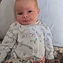 Savannah joined the competition — help win amazing prizes! baby, infant, child, face, pillow, blanket, bed, floral_pattern, clothing, onesie, red_hair, skin, cute, portrait, lying_down, indoors, comfort, soft, young, sleepy