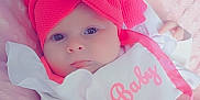 Savannah is registered to the contest to win money with this photo: baby, infant, pink_bow, headband, bib, white_clothing, pink_clothing, blanket, soft_texture, portrait, closeup, cute, child, newborn, face, hand, lying_down, expression, indoor, cozy