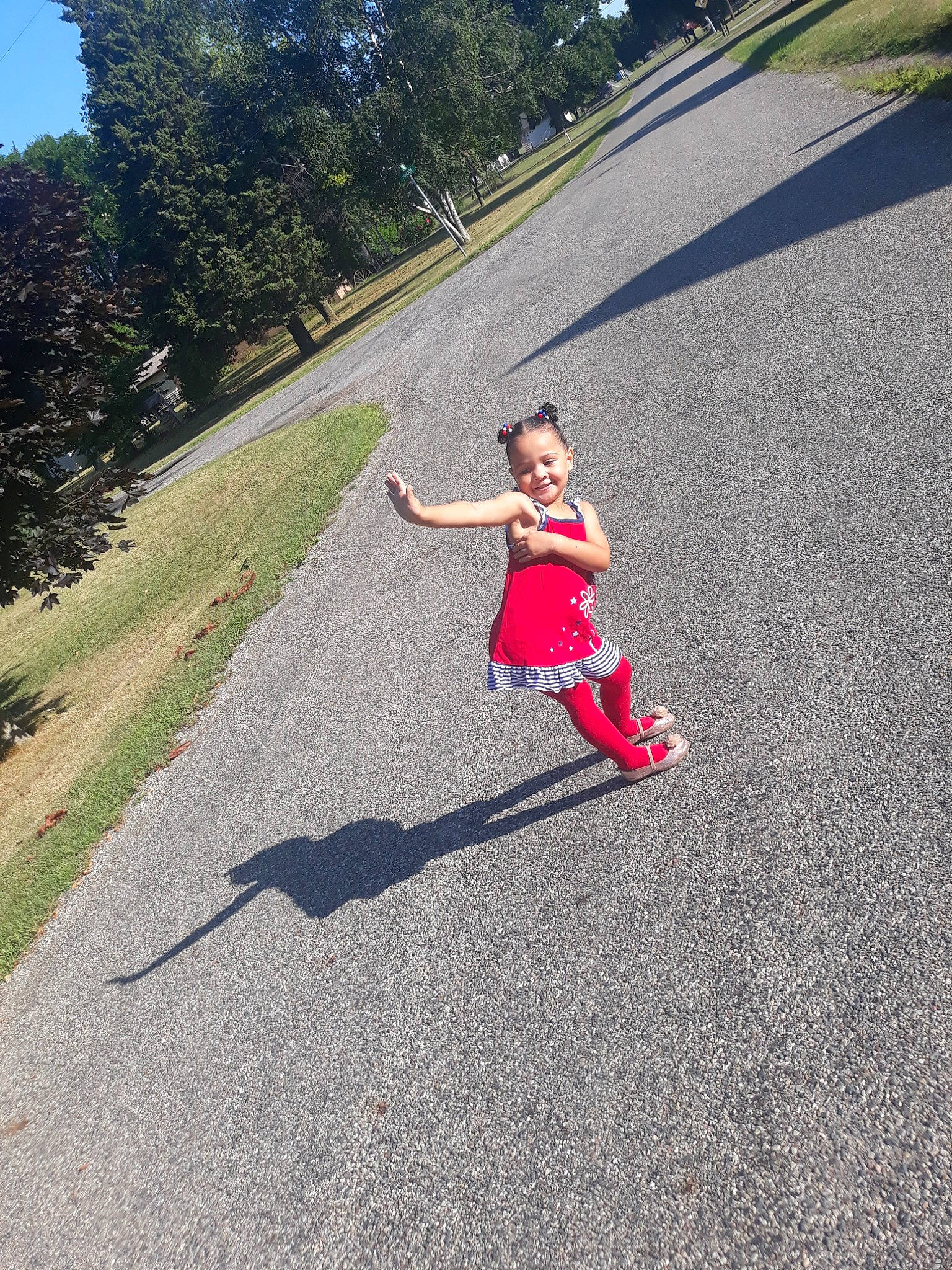 Janiah is registered to the contest to win money with this photo: asphalt, dress, driveway, grass, joy, leisure, person, photography, plant, recreation, red, road, shadow, summer, tree, vacation