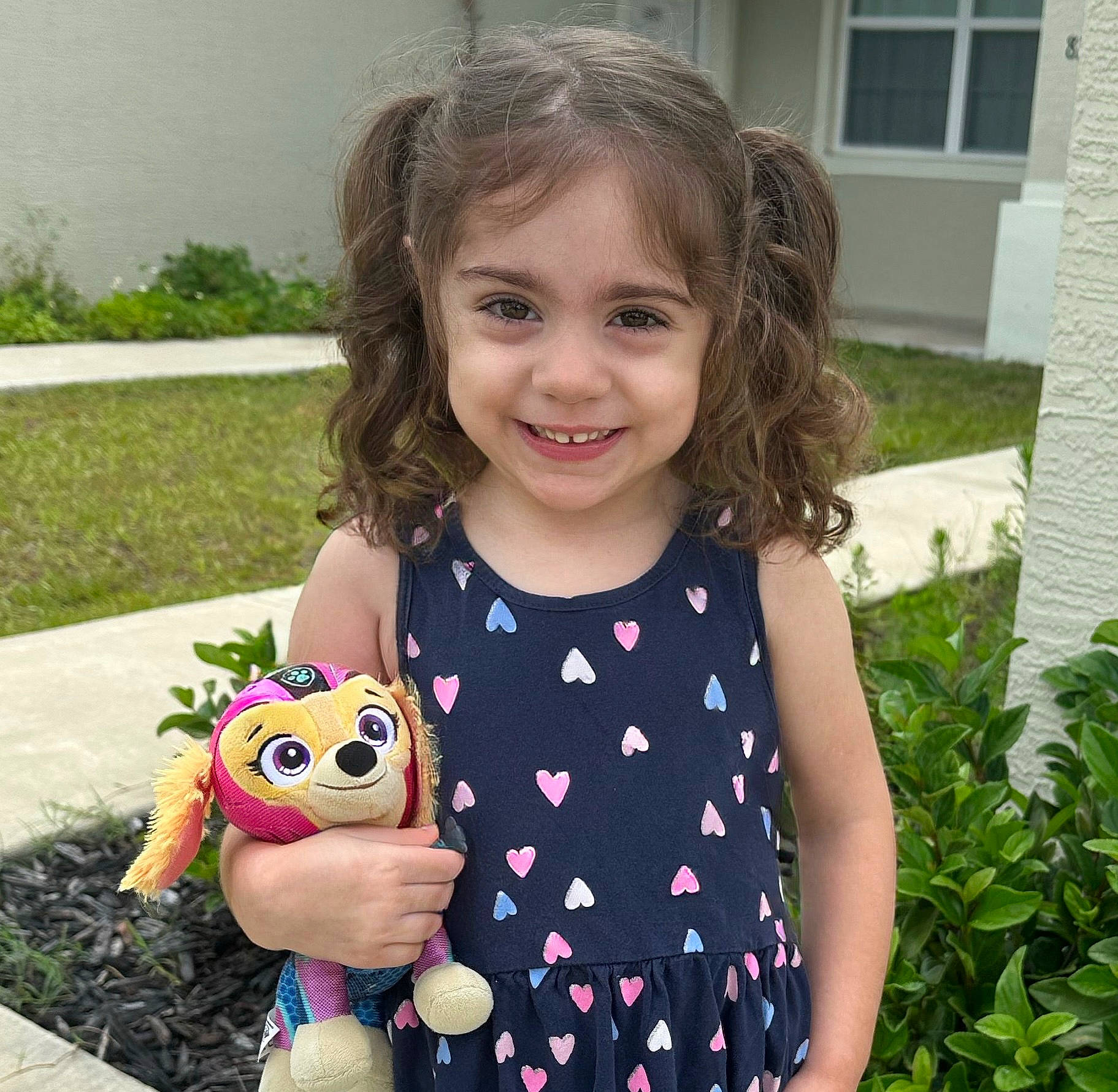 Lyla is registered to the contest to win money with this photo: baby_toddler_clothing, child, doll, fun, garden, grass, happy, head, joy, pattern, person, pink, plant, play, plush, sleeve, smile, stuffed_toy, t_shirt, toddler
