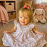 Sayler is registered to the contest to win money with this photo: toddler, child, girl, smiling, dress, bow, hair, indoor, rug, plush_toy, bunny, decor, basket, shelf, window, curtain, floor, cute, portrait, happy