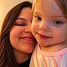 child, toddler, woman, face, smile, portrait, close_up, happy, person, skin, hair, eyes, indoor, warm_light, casual_clothing, family, love, affection, cute, head