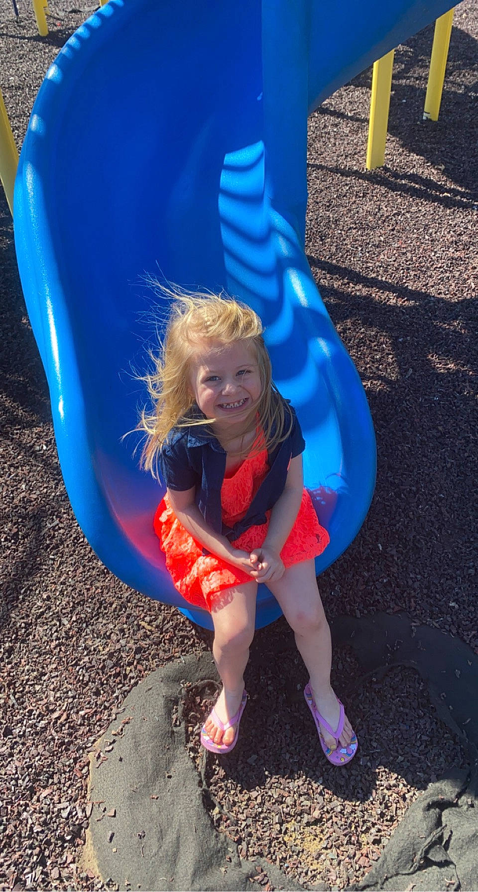 Aubrey is registered to the contest to win money with this photo: azure, beauty, blue, child, chute, city, electric_blue, fun, grass, happy, human_leg, joy, leisure, outdoor_play_equipment, person, play, playground, purple, recreation, sitting