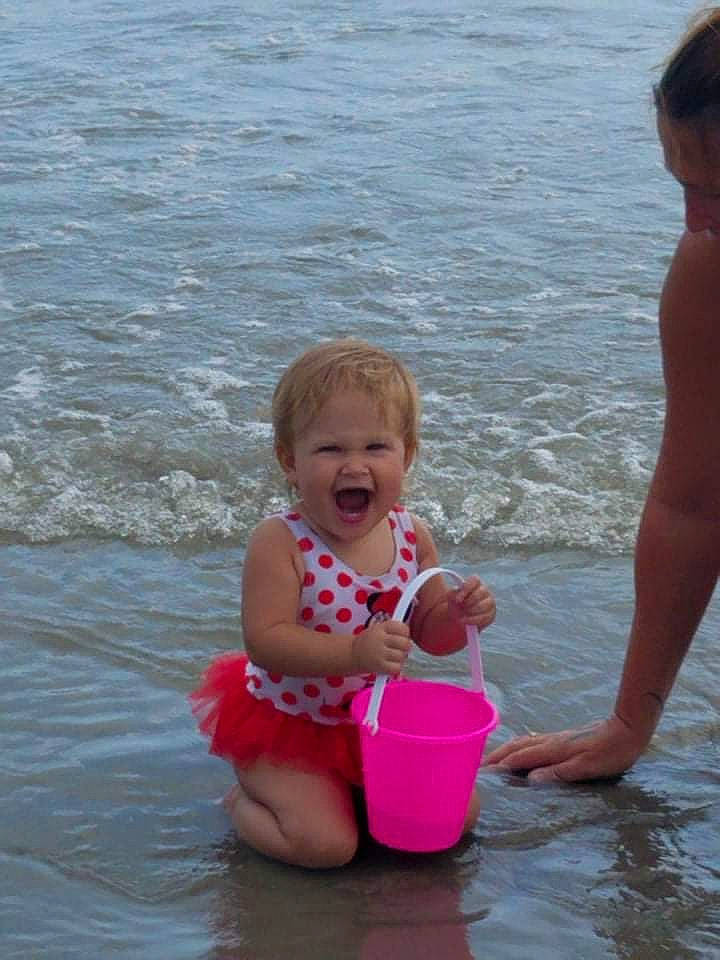 Mila joined the competition — help win amazing prizes! barefoot, beach, body_of_water, facial_expression, fun, happy, lake, leg, leisure, people, people_in_nature, people_on_beach, person, photograph, recreation, sand, shorts, smile, summer, toddler