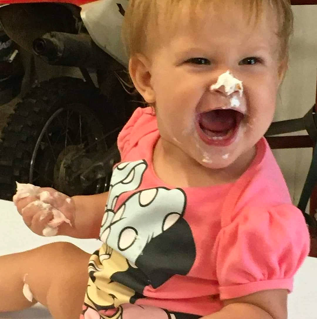 Mila is registered to the contest to win money with this photo: automotive_tire, baby_toddler_clothing, cheek, eye, gesture, hairstyle, happy, head, human_body, lip, mouth, neck, nose, organ, person, skin, sleeve, smile, tire, tooth