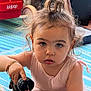 toddler, child, water_bottle, blue_eyes, pony_tail, bracelet, pink_clothing, indoor, toy_wagon, striped_mat, curly_hair, cute, focused, hand, face, person, young_child, playing, floor, expression