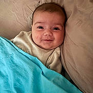 Luna a rejoint le concours — aidez-le/la à gagner de superbes lots ! baby, smile, blanket, pillow, bed, cozy, face, infant, child, sleepwear, cute, indoors, resting, portrait, tucked_in, comfort, soft, young, peaceful, lying_down