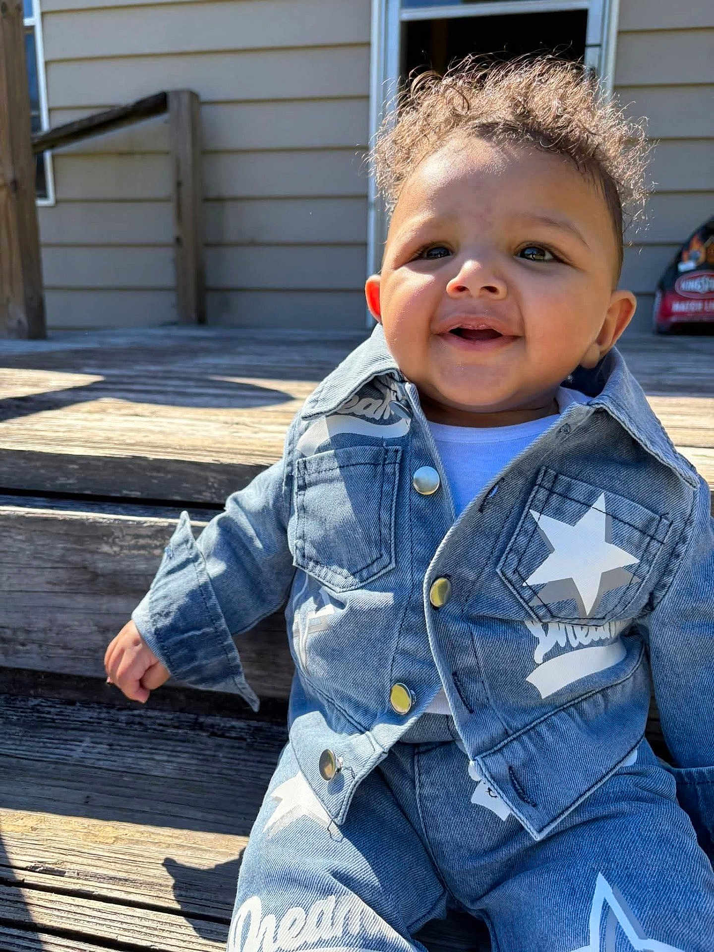 Legend Isaiah Powell is registered to the contest to win money with this photo: toddler, child, denim, jacket, pants, stars, smile, curly_hair, outdoor, wooden_steps, sunlight, happy, fashion, clothing, cute, baby, person, casual, daylight, portrait