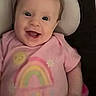 Hailey is registered to the contest to win money with this photo: baby, child, clothing, comfort, cushion, cute, face, happy, head, indoors, infant, joy, person, pink_clothing, portrait, rainbow, seat, smile, sun, young