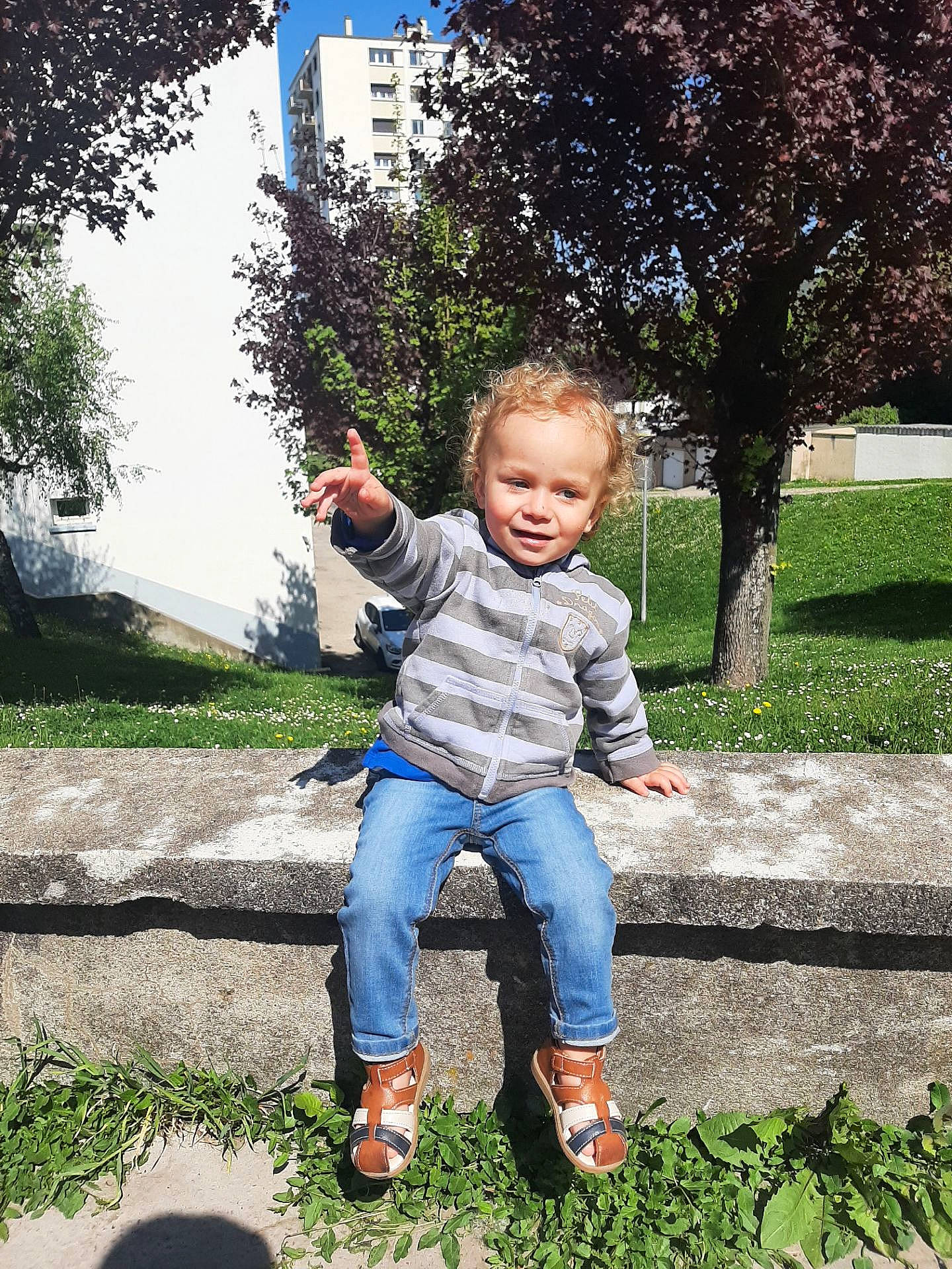 Adélino a rejoint le concours — aidez-le/la à gagner de superbes lots ! baby, boot, botany, denim, fun, garden, grass, groundcover, happy, jeans, lawn, leaf, leisure, people_in_nature, person, plant, sitting, sky, smile, toddler