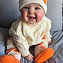 Jack joined the competition — help win amazing prizes! baby, blue_eyes, child, clothing, couch, cozy, cute, face, footwear, happy, hat, indoor, orange, person, plush, pompon, sitting, smiling, socks, white