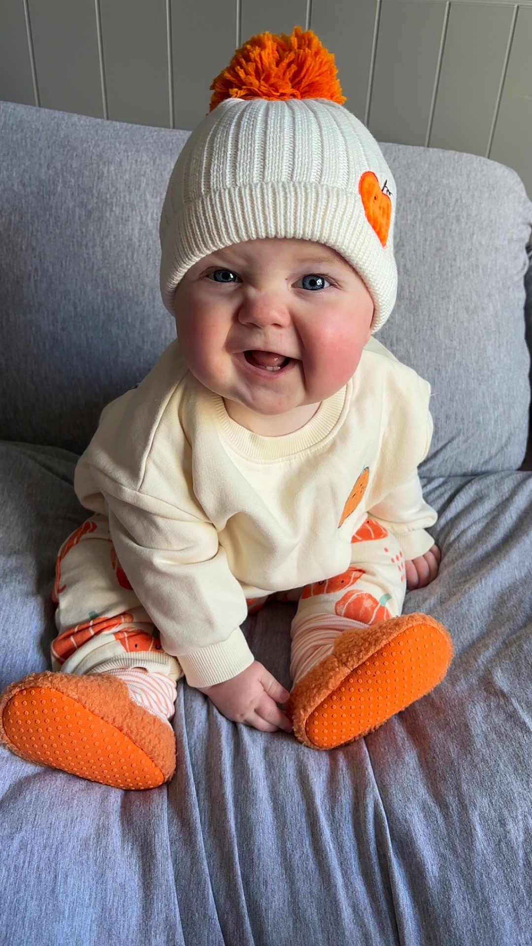 Jack joined the competition — help win amazing prizes! baby, blue_eyes, child, clothing, couch, cozy, cute, face, footwear, happy, hat, indoor, orange, person, plush, pompon, sitting, smiling, socks, white