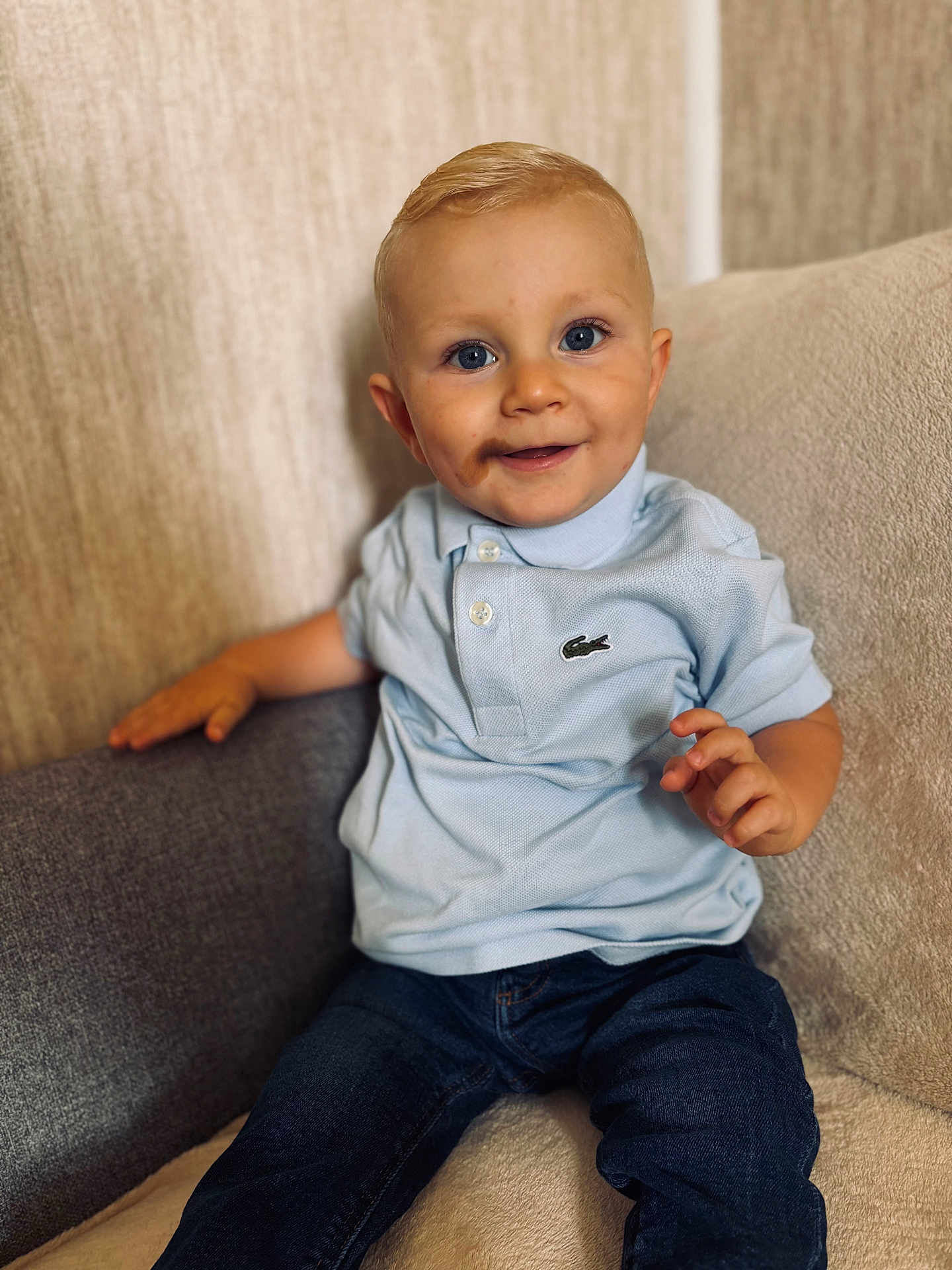 Tigane a rejoint le concours — aidez-le/la à gagner de superbes lots ! toddler, child, smiling, blue_eyes, polo_shirt, jeans, sitting, couch, indoor, blond_hair, happy, casual_clothing, portrait, young_child, cute, face, person, home, cozy, comfortable