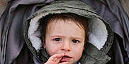 Ilyann participe au concours pour gagner de l'argent avec cette photo : toddler, child, face, hood, jacket, coat, hand, stroller, blanket, curious, portrait, young_child, outdoor_clothing, expression, warm_clothing, baby, person, cute, eyes, winter