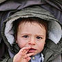toddler, child, face, hood, jacket, coat, hand, stroller, blanket, curious, portrait, young_child, outdoor_clothing, expression, warm_clothing, baby, person, cute, eyes, winter