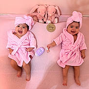 Joanna And Elianna is registered to the contest to win money with this photo: babies, twins, infants, smiling, pink, bathrobes, towels, turbans, bunny_toys, nursery, milestone, six_months, portrait, indoor, lying_down, baby_care, blanket, happy, siblings, photography