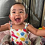 Yumi is registered to the contest to win money with this photo: arms_outstretched, baby, baby_seat, baby_toys, carpet, child, colorful_clothing, couch, dress, face, furniture, happy, home, indoor, infant, person, playful, safety_gate, smiling, wood