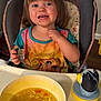 Elaina joined the competition — help win amazing prizes! toddler, child, high_chair, spoon, soup, bowl, rice, carrot, food, meal, smile, happy, shirt, cartoon_character, princess, penguin, sippy_cup, indoor, kitchen, feeding