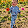 child, toddler, portrait, outdoor, garden, flower_field, flowers, marigold, zinnia, smiling, standing, holding_flowers, blue_pajamas, colorful_clothing, sunlight, nature, plants, grass, soil, shoes