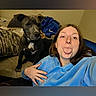 Blu is registered to the contest to win money with this photo: woman, dog, selfie, indoor, blue_hoodie, black_dog, couch, blanket, tongue_out, casual, pet, smiling, relaxed, portrait, home, fun, friendship, companion, furniture, cozy