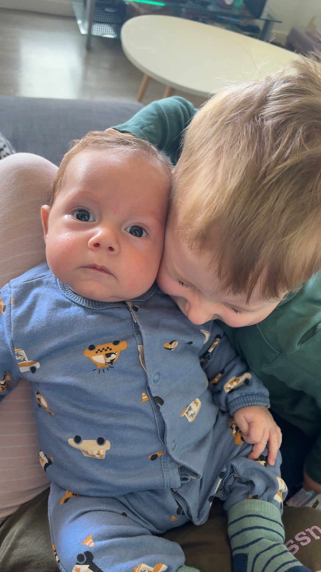 Malo participe au concours pour gagner de l'argent avec cette photo : affection, baby, blue_clothing, child, couch, cozy, cute, face, family, floor, head, indoor, light, living_room, pajamas, person, sibling, skin, table, toddler