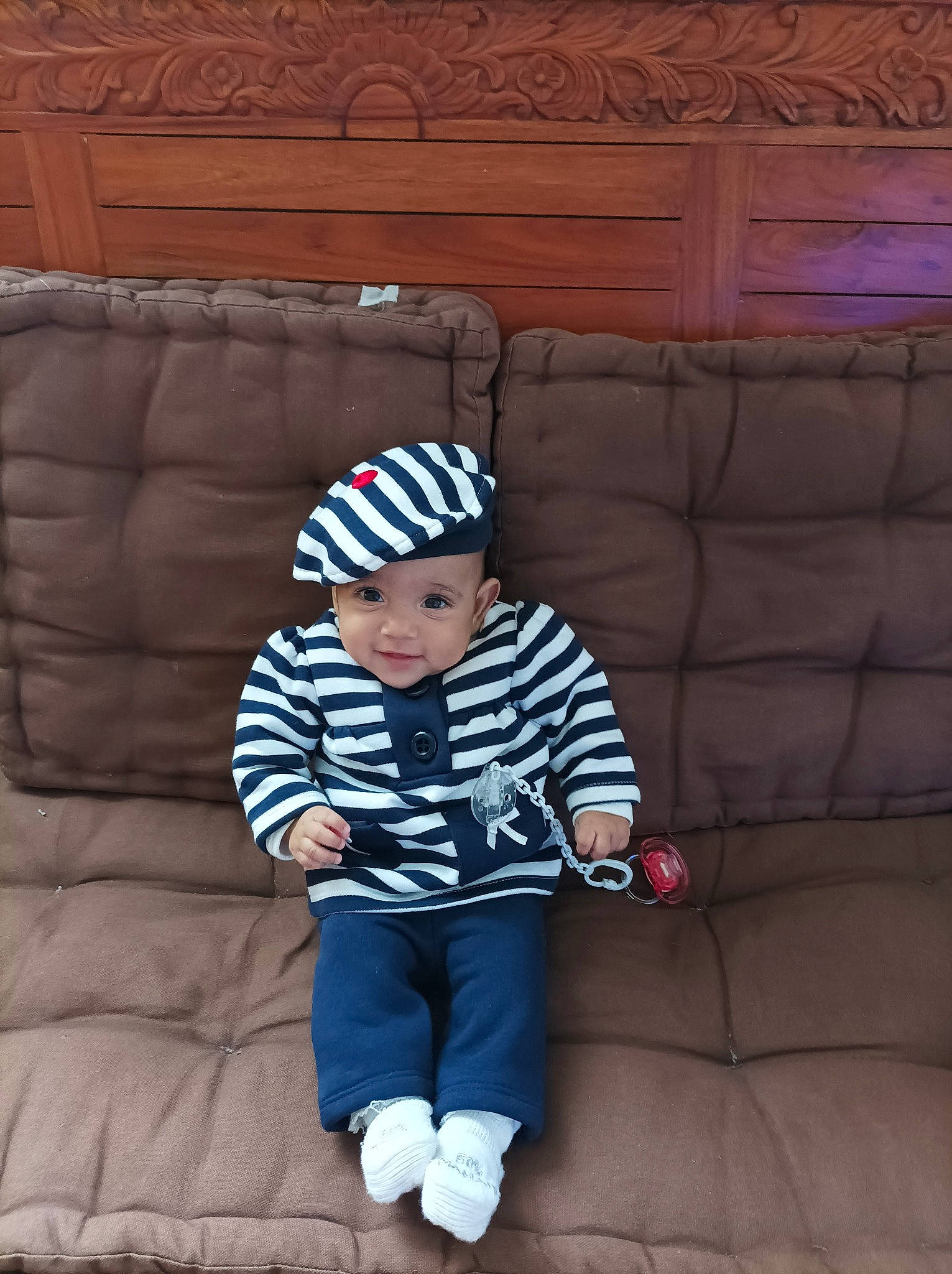Mencya participe au concours pour gagner de l'argent avec cette photo : baby, baby_toddler_clothing, beanie, cap, child, comfort, couch, electric_blue, flooring, fun, headwear, magenta, pattern, person, plant, sitting, sleeve, t_shirt, toddler, tree
