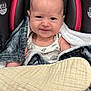 baby, infant, car_seat, blanket, smiling, face, child, cozy, indoors, clothing, cute, portrait, person, seat, upclose, expression, warm, comfort, head, young