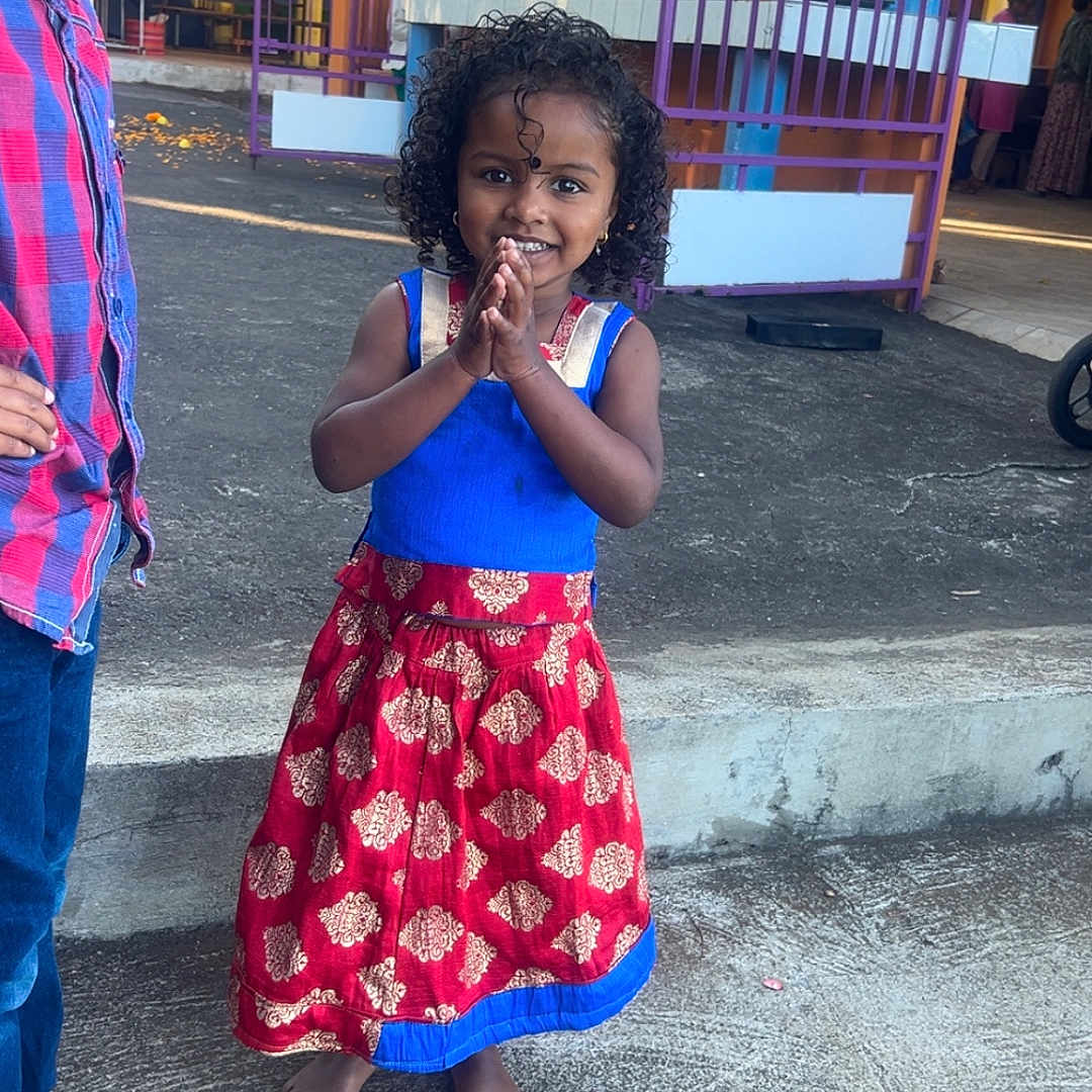 Maëllys a rejoint le concours — aidez-le/la à gagner de superbes lots ! barefoot, boy, casual_clothing, child, colorful, concrete, cultural_event, curly_hair, daylight, festival, girl, hands_together, happy, outdoor, people, pillar, portrait, purple_fence, smiling, traditional_dress