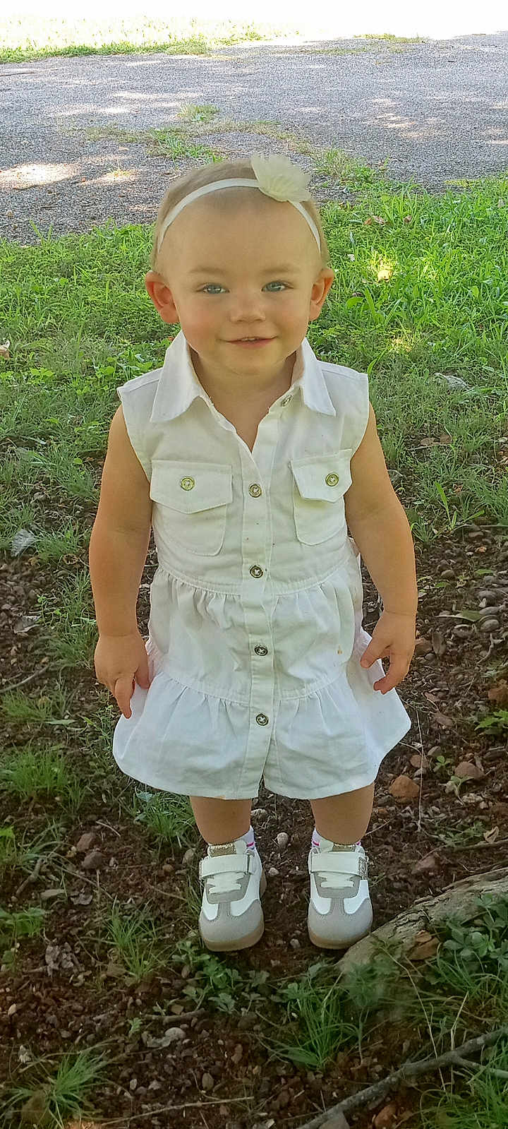 Kaya joined the competition — help win amazing prizes! child, toddler, outdoor, grass, dirt, white_dress, headband, flower, sneakers, smiling, person, nature, greenery, sunlight, portrait, standing, happy, casual_clothing, baby, cute