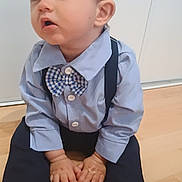 Eliott a rejoint le concours — aidez-le/la à gagner de superbes lots ! toddler, child, boy, barefoot, blue_shirt, bow_tie, suspenders, hat, cap, floor, wooden_floor, sitting, indoors, cute, curious, hands, feet, portrait, clothing, face